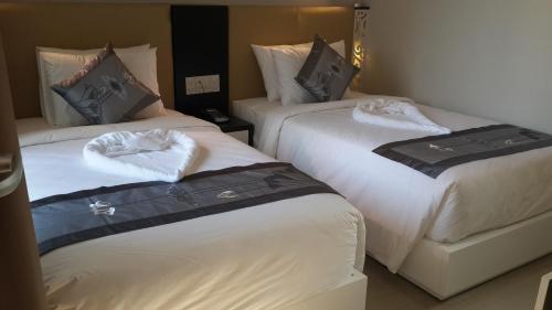 2 Betten in einem Hotelzimmer mit Handtüchern darauf in der Unterkunft Muine Sports Hotel in Mui Ne