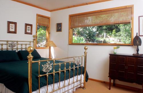 a bedroom with a bed and a window at Mount Joy Cottages in Knysna