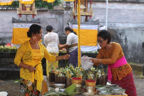 two women standing in front of a market selling flowers at Mojito Beach Villas in Kubutambahan