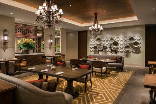 a restaurant with tables and chairs and chandeliers at Grand Hyatt Jakarta in Jakarta