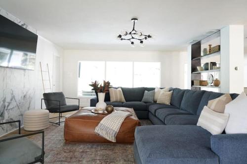 a living room with a blue couch and a table at Remodeled 4BR Pool Home / Golf View/Near Beaches in Sarasota