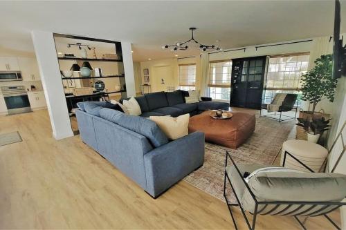 a living room with a blue couch and a table at Remodeled 4BR Pool Home / Golf View/Near Beaches in Sarasota