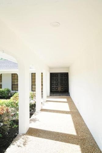 a white house with a black door at Remodeled 4BR Pool Home / Golf View/Near Beaches in Sarasota