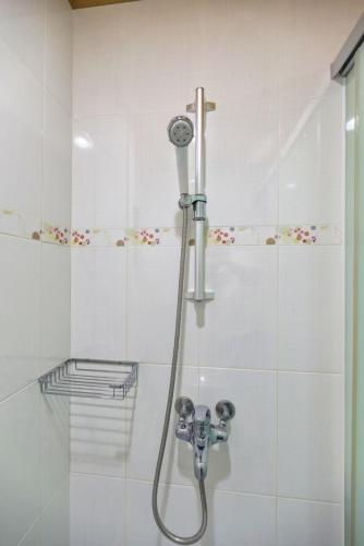 a shower with a hose in a bathroom at 客拉客民宿 Clock B&B in Huxi