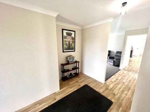 a living room with white walls and a black rug at Napolean Holiday Retreat in Vasse