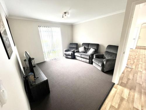 a living room with two leather couches and a television at Napolean Holiday Retreat in Vasse