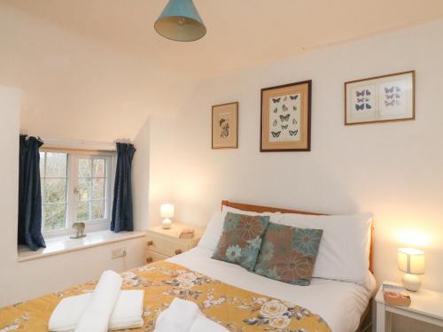 a bedroom with a bed and a window at River Cottage in Burton Bradstock