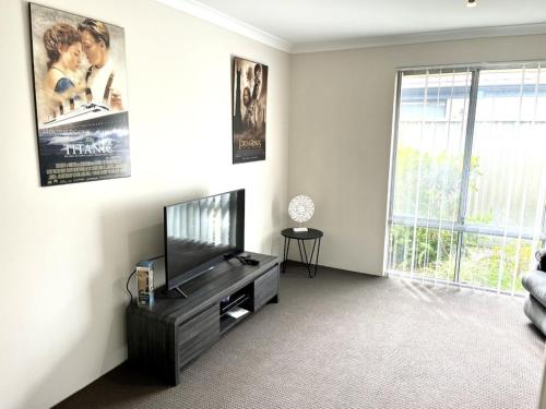 a living room with a flat screen tv and a couch at Napolean Holiday Retreat in Vasse