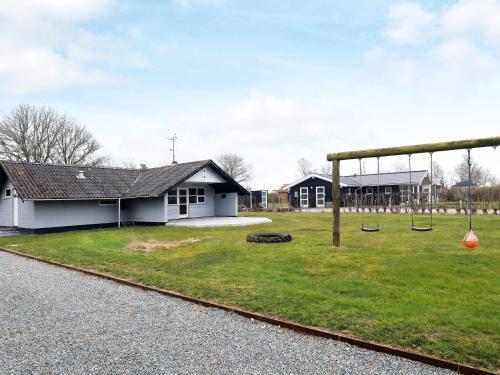 a playground with swings in front of a house at Seaside Charm in Ristinge-By Traum in Humble