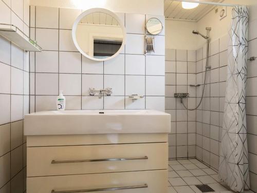 La salle de bains blanche est pourvue d'un lavabo et d'un miroir. dans l'établissement Holiday home Frørup IV, à Frørup