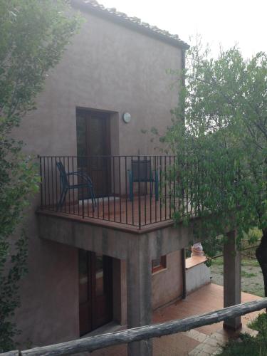 a house with a balcony with two chairs on it at Agriturismo Gelso in Castellana Sicula