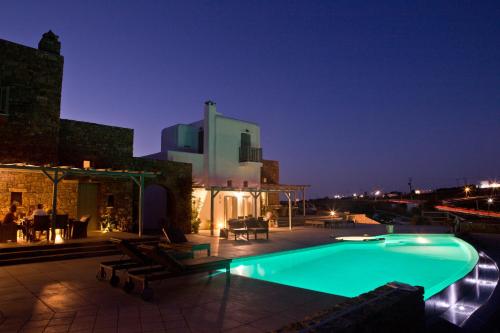 a swimming pool in front of a building at night at Niriides Homes & Villas in Elia Beach