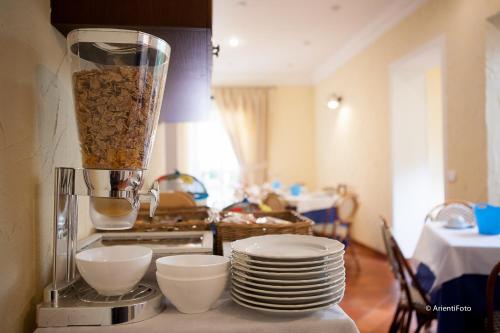 a kitchen counter with plates and a blender with food at Albergo del Lago in Capalbio