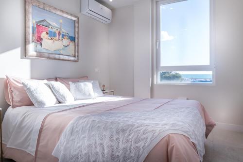 a bedroom with a large bed with a large window at Atico Puerto Sol in Altea