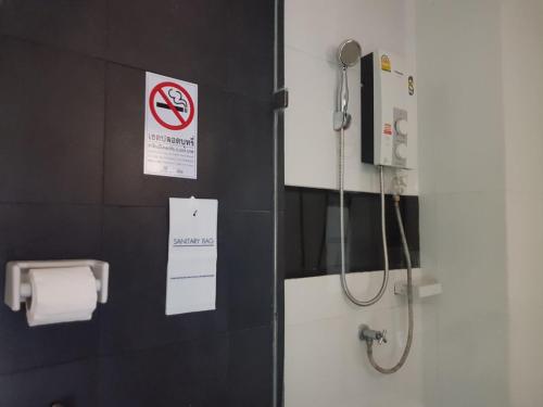 a bathroom with a shower and a toilet paper dispenser at Elite Residence Phitsanulok SHA in Phitsanulok