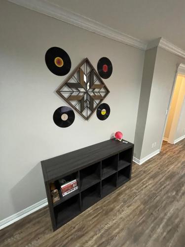 a living room with a black shelf and records on the wall at The Drover House by USAO in Chickasha, Fenced Yard, King Bed, Smart TV, High Speed WIFI & Covered Parking in Chickasha