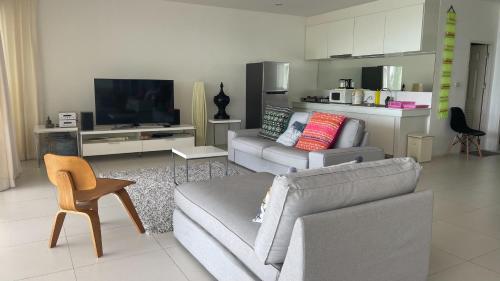 a living room with a couch and a tv at Kata Top Villas in Kata Beach