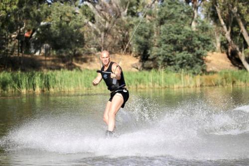 a man is water skiing on a lake at Eildon Parkview Motor Inn Room 4 in Eildon
