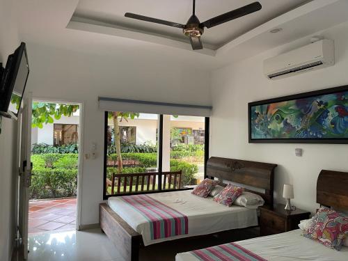 a bedroom with two beds and a balcony at Hotel Melgar Villa Valeria Boutique in Melgar