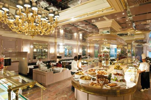 a restaurant with people preparing food in a buffet at Maritim Hotel München in Munich