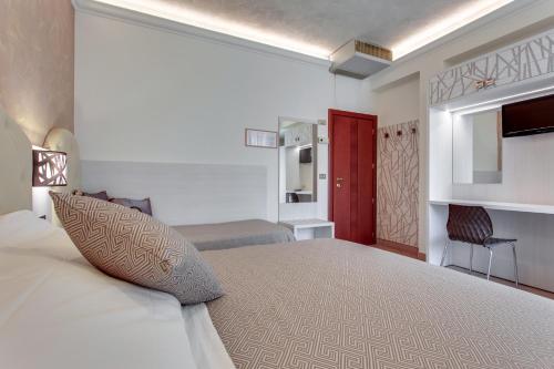 a bedroom with a large bed with a red door at Hotel Dolcevita in Cesenatico