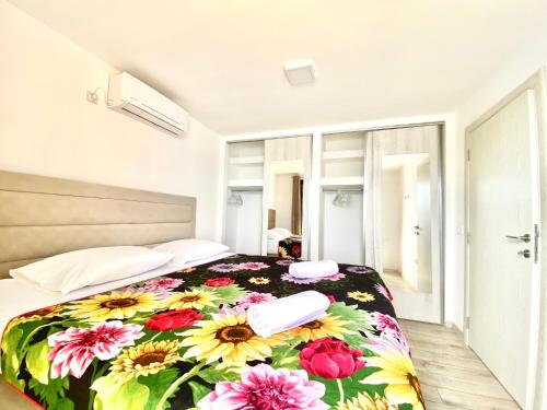 um quarto com uma cama com um cobertor floral em Lake River House Ada Bojana em Ulcinj