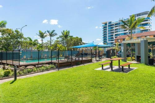 a park with benches and tables and a building at Broadwater Keys Holiday Apartments in Gold Coast