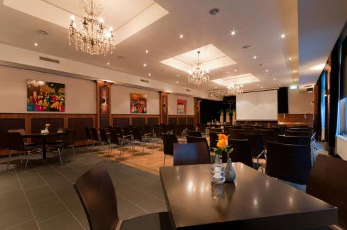 a conference room with tables and chairs and a screen at Hotel Restaurant St. Lambert in Helmond