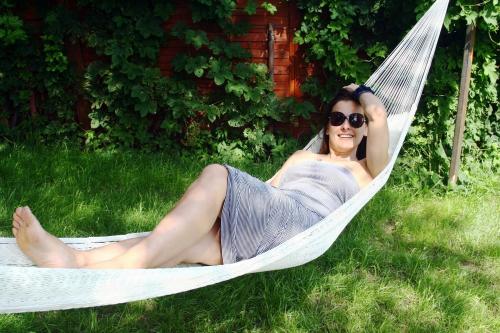 a woman is laying in a hammock at Villa Marina in Augustów
