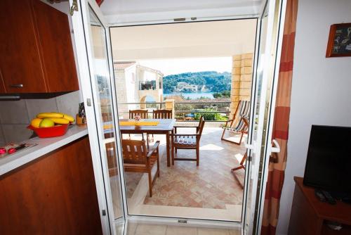 eine Küche mit einer Glastür, die zu einem Esszimmer führt in der Unterkunft Apartments Irene's place in Rogač