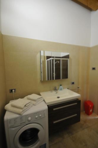 a bathroom with a washing machine and a sink at APPARTAMENTO MONTE - VALANDRO- in Comano Terme