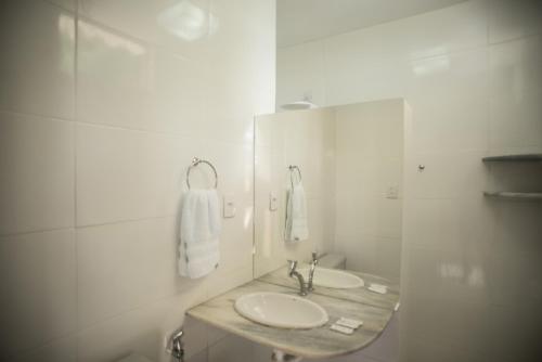 a white bathroom with two sinks and a mirror at Hotel Parque do Sol in Parnamirim