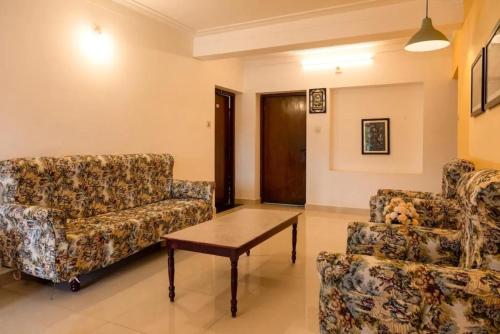a living room with two chairs and a coffee table at Aakash Rooms and Cottages, in Ooty