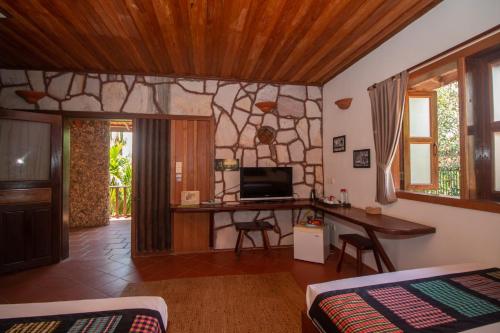 a bedroom with a desk and a tv in a room at TARA LODGE Haven of peace in Kep
