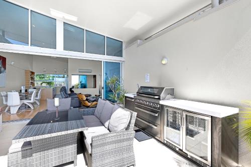 a kitchen and living room with a couch and a stove at Azure Sea Whitsunday Resort in Airlie Beach