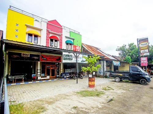 a group of buildings in a street with a truck at OYO Life 90587 Domen Homestay Syariah in Krui