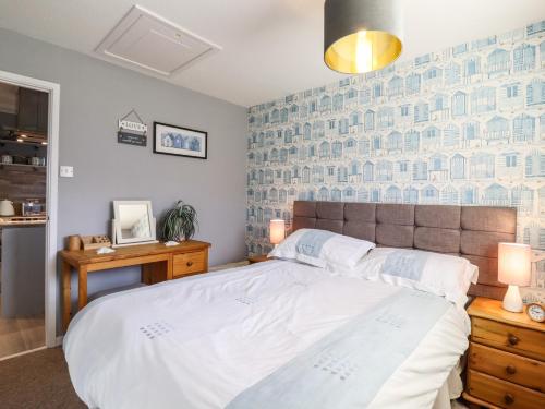 a bedroom with a large bed with a blue wall at Bungalow 14 in Lowestoft
