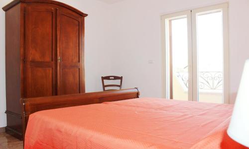 a bedroom with a bed and a wooden cabinet at Torre Vado Appartamento Vista Mare in Torre Vado