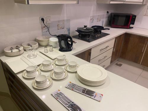 a kitchen counter with plates and dishes on it at Luxury Guest House in Bahria Town in Rawalpindi
