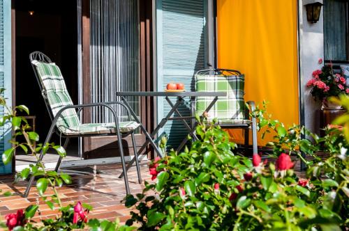 a table and two chairs on a porch with flowers at Hotel Effland -Sauna -Pool in Bayrischzell