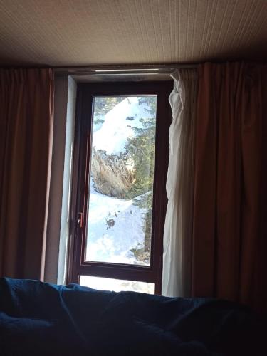 a window in a bedroom looking out at the snow at Studio transformé en 2 pièces avec cloison amovible sur La Plagne Bellecôte in Sangot