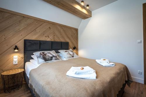 a bedroom with a large bed with towels on it at Willa Trawers in Zakopane