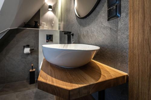 a bathroom with a white bowl sink on a wooden counter at Willa Trawers in Zakopane