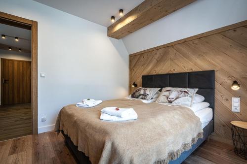 a bedroom with a large bed with towels on it at Willa Trawers in Zakopane