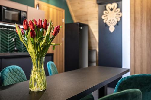a vase of red tulips sitting on a table at Willa Trawers in Zakopane