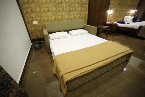 a large bed in a room with two beds at The Byke Heritage Resort - Matheran in Matheran