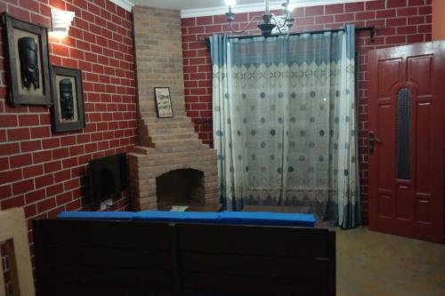 a bathroom with a shower and a brick wall at Parachichi House BNB in Arusha