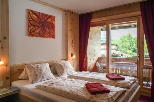 ゼルにあるAppartement Wilder Kaiser, Anni Kollerのベッドが2つと大きな窓がある寝室