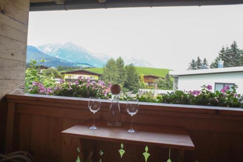 two wine glasses on a table in front of a window at Appartement Wilder Kaiser, Anni Koller in Söll