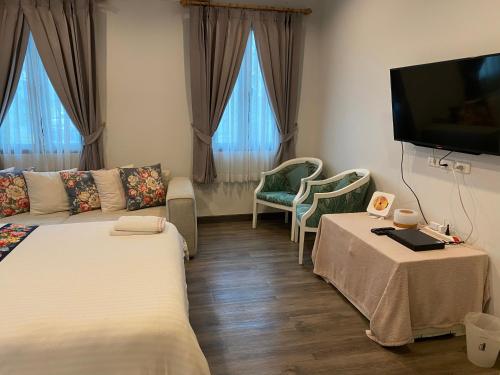 Una sala de estar con dos camas y un televisor de pantalla plana. en Ban 5 Rai Pool Villa, en Chiang Mai